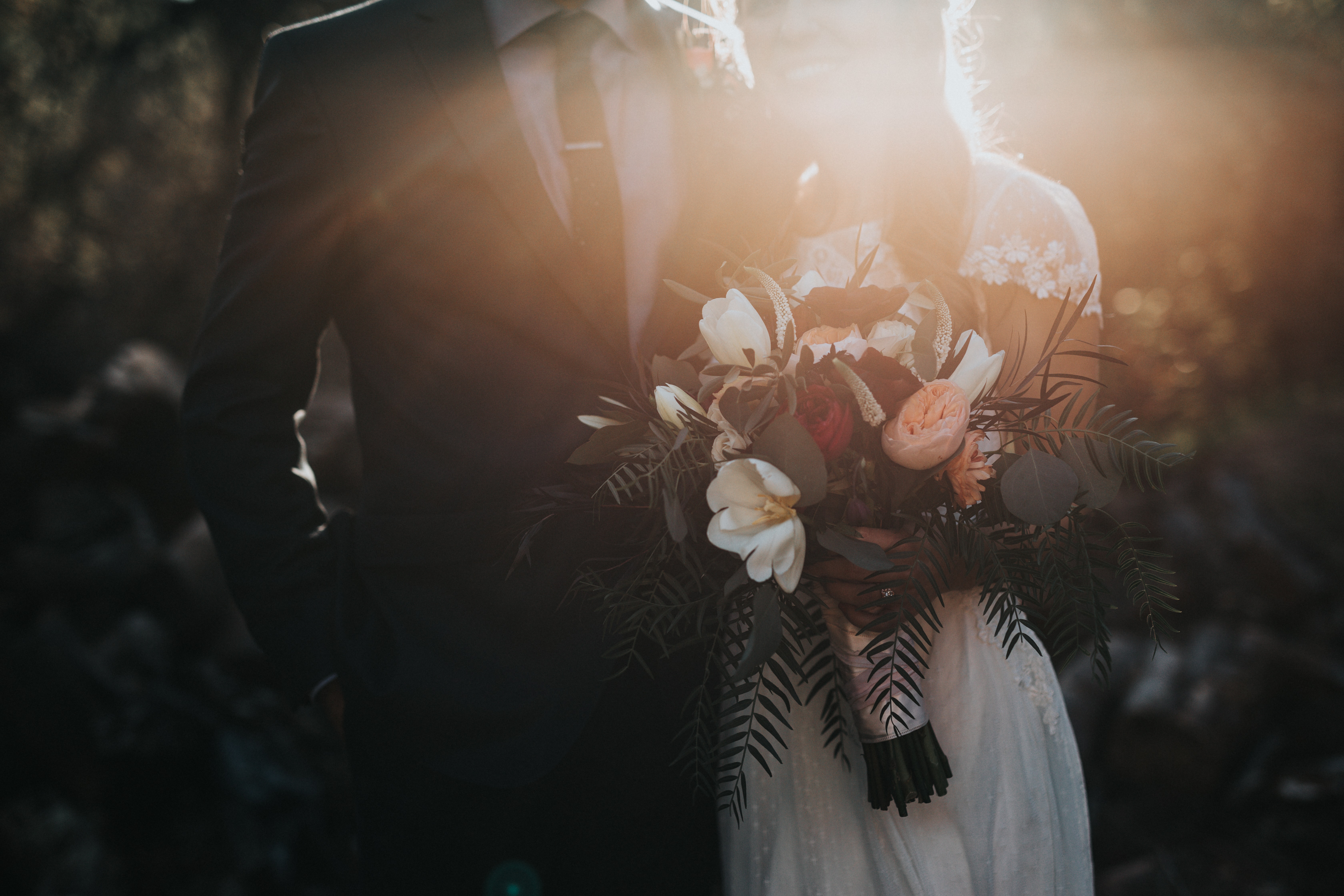 A bridal couple with large bouquet of flowers. 